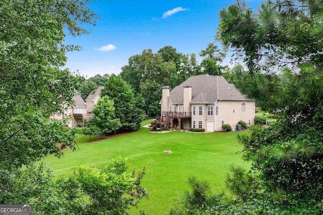 106 April Walk, Mcdonough, GA 30253 - back of property featuring a lawn, a deck, a chimney, and stucco siding