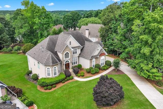106 April Walk, Mcdonough, GA 30253 - view of front facade with stucco siding, stone siding, a front yard, roof with shingles, and driveway