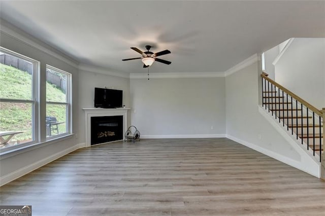 6867 Kate, Flowery Branch, GA 30542 - unfurnished living room with ornamental molding, wood finished floors, a fireplace, ceiling fan, and stairs