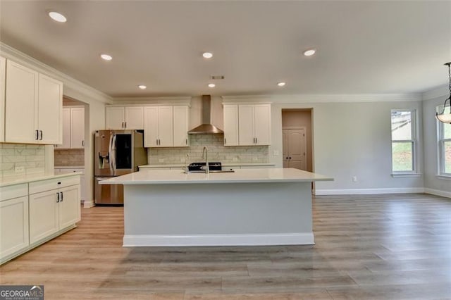 6867 Kate, Flowery Branch, GA 30542 - kitchen with wall chimney range hood, stainless steel fridge with ice dispenser, light countertops, crown molding, and a kitchen island with sink