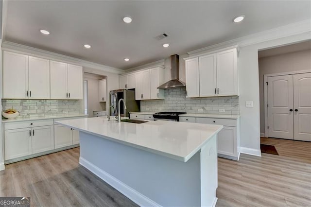 6867 Kate, Flowery Branch, GA 30542 - kitchen featuring wall chimney exhaust hood, range, light countertops, a center island with sink, and crown molding