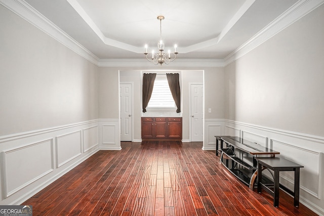 915 Pebble Creek Trl, Suwanee, GA 30024 - dining space featuring a chandelier, a raised ceiling, dark wood finished floors, wainscoting, and a decorative wall