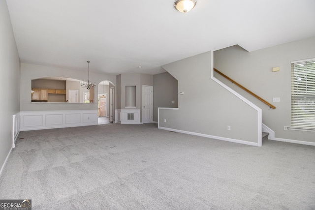801 Tulip Poplar Way Unit 2501, Lawrenceville, GA 30044 - unfurnished living room with a chandelier, arched walkways, carpet floors, and stairs