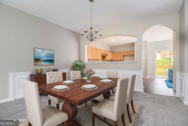 801 Tulip Poplar Way Unit 2501, Lawrenceville, GA 30044 - dining space with arched walkways, a wainscoted wall, light carpet, a chandelier, and a decorative wall