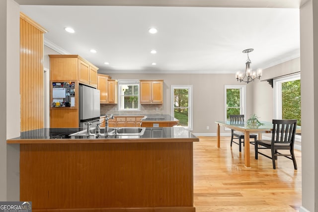 379 Sweetwater Rdg, Hoschton, GA 30548 - kitchen featuring ornamental molding, freestanding refrigerator, a peninsula, tasteful backsplash, and a chandelier