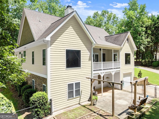 379 Sweetwater Rdg, Hoschton, GA 30548 - back of house with a chimney, roof with shingles, a gate, a balcony, and a patio