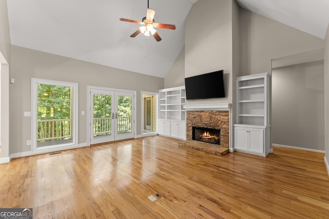 379 Sweetwater Rdg, Hoschton, GA 30548 - unfurnished living room with high vaulted ceiling, ceiling fan, a fireplace, and light wood-style floors
