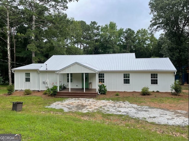 407 Johnstonville Rd, Barnesville, GA 30204 - single story home with board and batten siding, covered porch, a metal roof, and a front yard