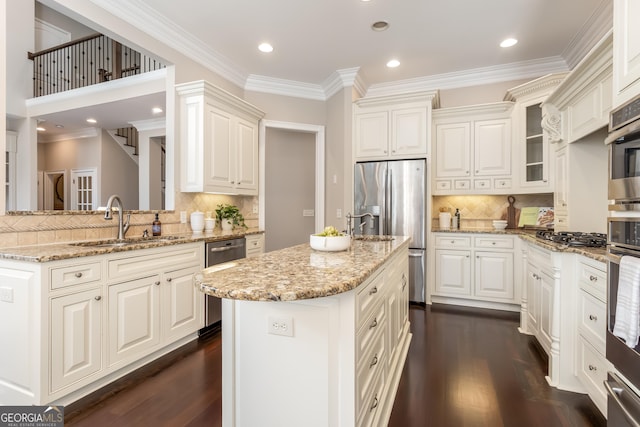 110 Wellington Way, Canton, GA 30115 - kitchen featuring stainless steel appliances, dark wood finished floors, decorative backsplash, a kitchen island with sink, and light stone counters