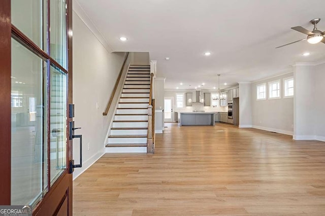 148 Palm St, Holly Springs, GA 30115 - unfurnished living room featuring crown molding, light wood finished floors, a ceiling fan, recessed lighting, and stairs