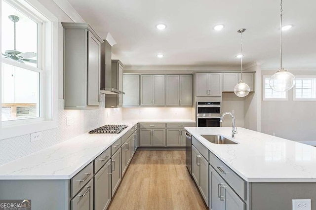 148 Palm St, Holly Springs, GA 30115 - kitchen with gray cabinets, appliances with stainless steel finishes, backsplash, light wood-type flooring, and a kitchen island with sink