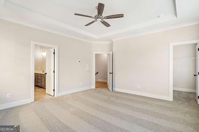 148 Palm St, Holly Springs, GA 30115 - unfurnished bedroom with a raised ceiling, light colored carpet, a spacious closet, crown molding, and connected bathroom