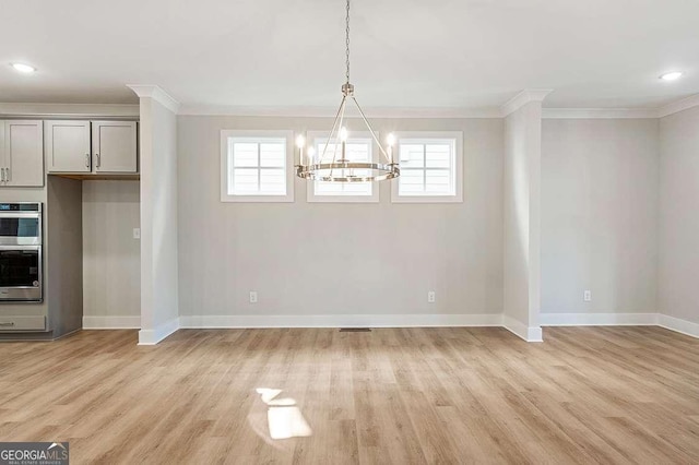 148 Palm St, Holly Springs, GA 30115 - unfurnished dining area featuring a chandelier, crown molding, light wood finished floors, and plenty of natural light