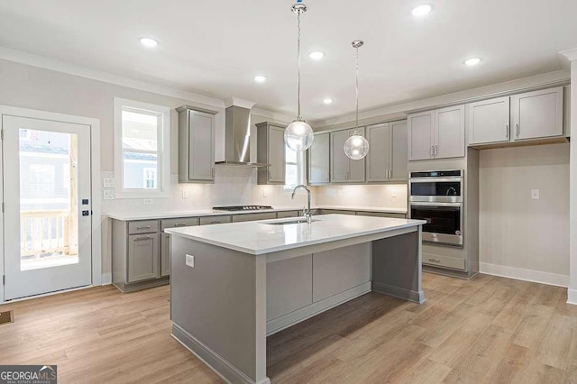 148 Palm St, Holly Springs, GA 30115 - kitchen with gray cabinets, wall chimney range hood, appliances with stainless steel finishes, decorative backsplash, and crown molding