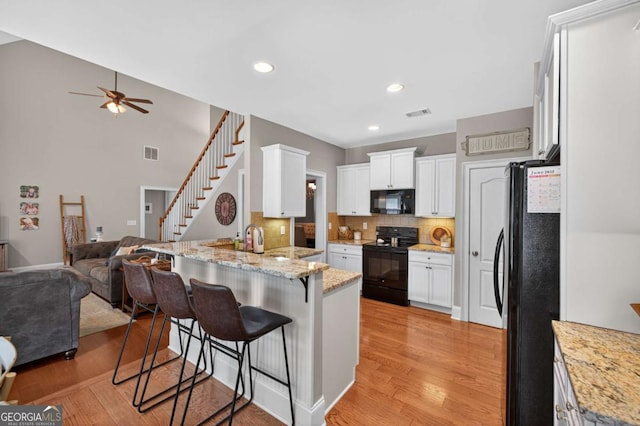 43 Emily Ln, Bogart, GA 30622 - kitchen featuring black appliances, a peninsula, open floor plan, a ceiling fan, and light wood-type flooring