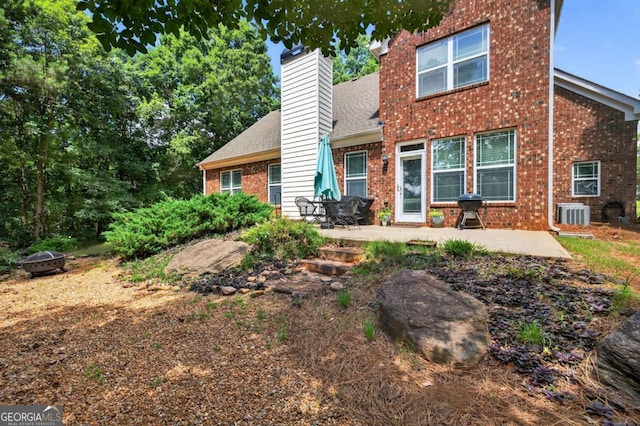 43 Emily Ln, Bogart, GA 30622 - view of front facade featuring an outdoor fire pit, brick siding, a patio area, a chimney, and a shingled roof