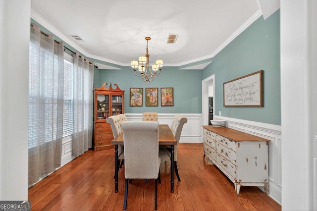43 Emily Ln, Bogart, GA 30622 - dining room featuring a chandelier, crown molding, wainscoting, wood finished floors, and a decorative wall