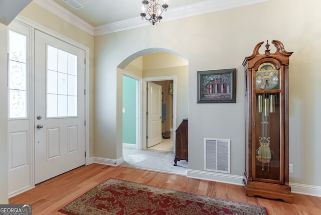 1071 Creekwood Cir, Madison, GA 30650 - foyer featuring arched walkways, wood finished floors, and crown molding