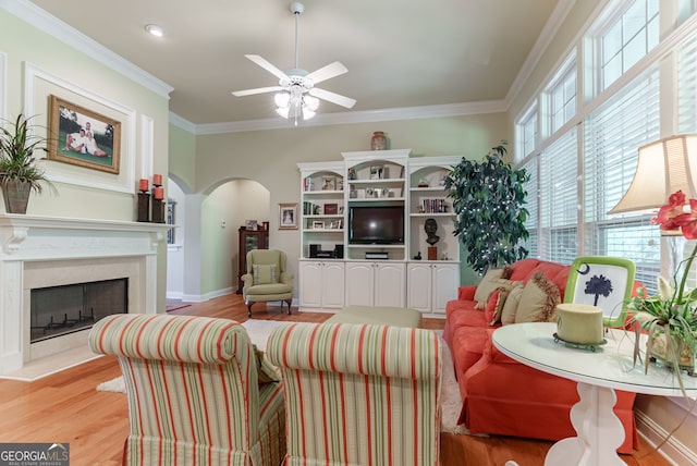 1071 Creekwood Cir, Madison, GA 30650 - living area featuring arched walkways, light wood-type flooring, ceiling fan, a premium fireplace, and crown molding