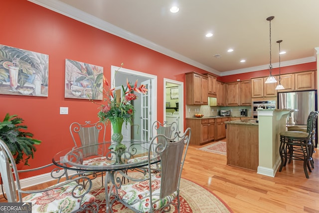 1071 Creekwood Cir, Madison, GA 30650 - dining room with light wood finished floors, crown molding, washer and dryer, and recessed lighting