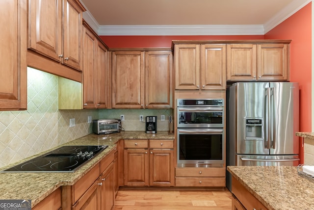 1071 Creekwood Cir, Madison, GA 30650 - kitchen featuring stainless steel appliances, crown molding, light wood-type flooring, light stone countertops, and tasteful backsplash