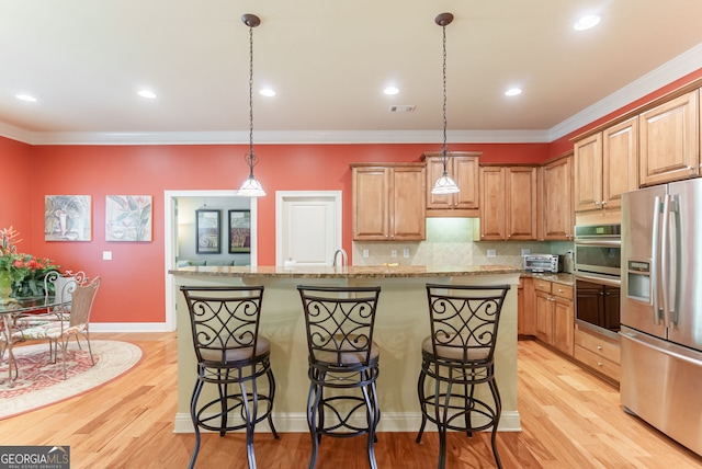 1071 Creekwood Cir, Madison, GA 30650 - kitchen with stainless steel appliances, decorative backsplash, a kitchen breakfast bar, ornamental molding, and an island with sink