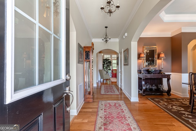 1071 Creekwood Cir, Madison, GA 30650 - entrance foyer featuring arched walkways, light wood-style flooring, crown molding, and a chandelier