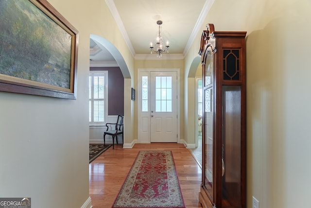 1071 Creekwood Cir, Madison, GA 30650 - doorway with ornamental molding, arched walkways, a chandelier, and light wood-type flooring