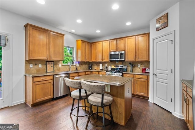 109 Hale View Cir, Canton, GA 30114 - kitchen with appliances with stainless steel finishes, a kitchen bar, decorative backsplash, recessed lighting, and dark wood-style flooring