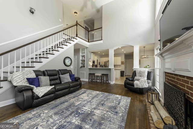 481 Fields Ferry Dr NE, Calhoun, GA 30701 - living room featuring ornate columns, hardwood / wood-style flooring, stairway, a brick fireplace, and a high ceiling