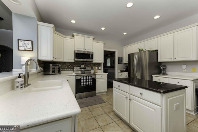 481 Fields Ferry Dr NE, Calhoun, GA 30701 - kitchen with stainless steel appliances, backsplash, a kitchen island, light tile patterned floors, and recessed lighting