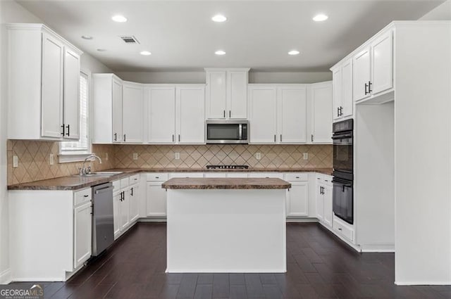 3366 Bridge Walk Dr, Lawrenceville, GA 30044 - kitchen featuring stainless steel appliances, dark wood-style floors, white cabinetry, tasteful backsplash, and a kitchen island