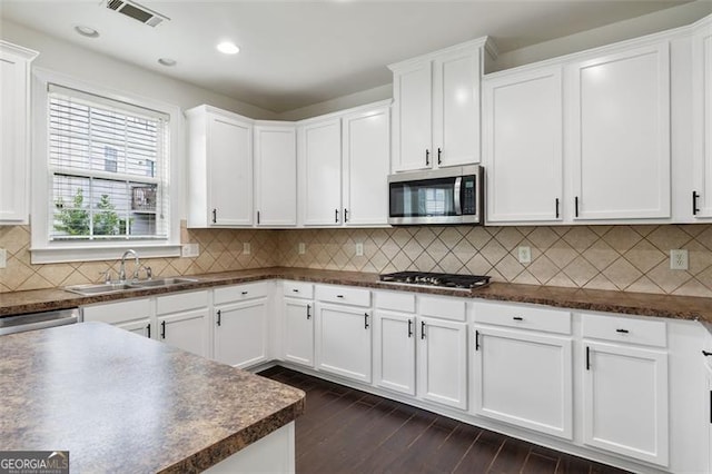3366 Bridge Walk Dr, Lawrenceville, GA 30044 - kitchen featuring appliances with stainless steel finishes, dark countertops, white cabinetry, dark wood-style floors, and recessed lighting
