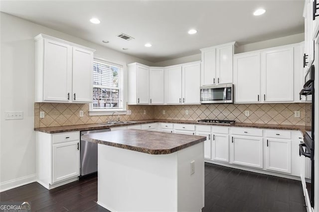3366 Bridge Walk Dr, Lawrenceville, GA 30044 - kitchen featuring stainless steel appliances, dark countertops, dark wood-style flooring, white cabinetry, and recessed lighting