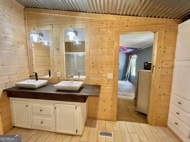 906 Billy Watts Cove Rd, Tiger, GA 30576 - bathroom with wood walls, double vanity, wood finished floors, and a shower with door