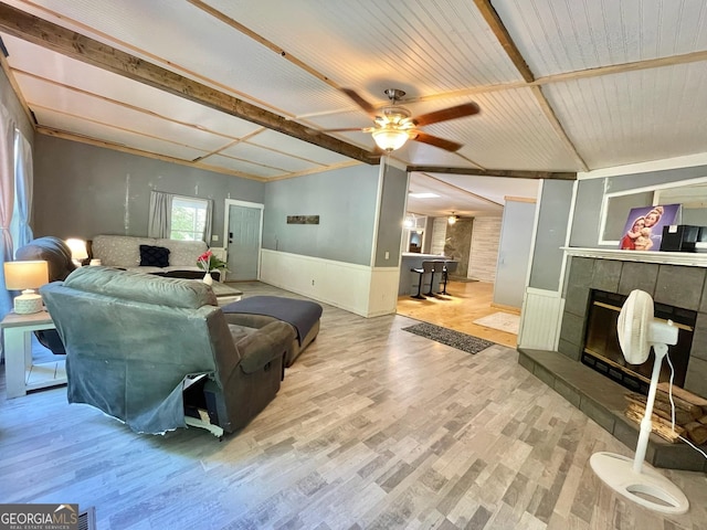 906 Billy Watts Cove Rd, Tiger, GA 30576 - living room featuring a tiled fireplace, a wainscoted wall, ceiling fan, wood finished floors, and beam ceiling