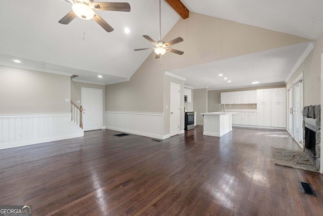 901 Jamesway Dr, Sparta, GA 31087 - unfurnished living room with a ceiling fan, a wainscoted wall, stairs, recessed lighting, and beamed ceiling
