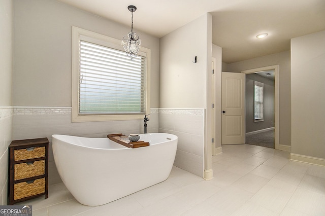 10 Ridgeview Ct, Newnan, GA 30263 - bathroom featuring tile walls, a soaking tub, a wainscoted wall, and tile patterned floors