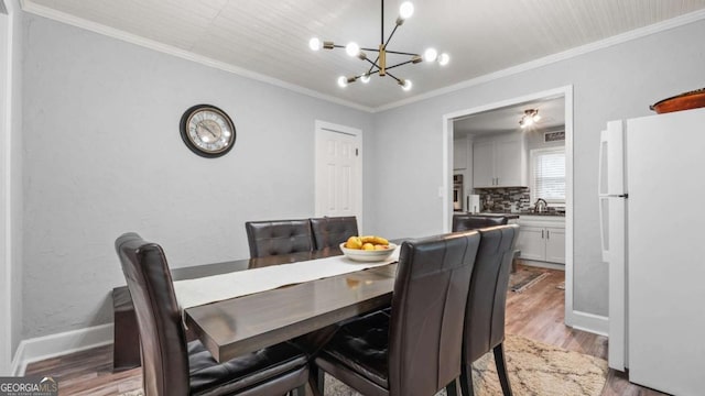 5599 Redan Cir, Stone Mountain, GA 30088 - dining space with a chandelier, crown molding, and light wood finished floors