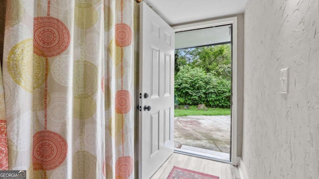 5599 Redan Cir, Stone Mountain, GA 30088 - doorway with a textured wall and wood finished floors