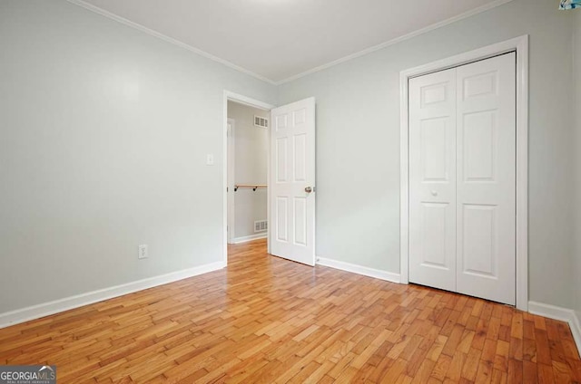 4212 Worth St NW, Acworth, GA 30101 - unfurnished bedroom with light wood-style floors, ornamental molding, and a closet