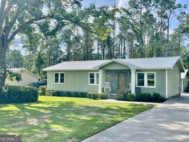 207 Timothy Ct, Vidalia, GA 30474 - view of front of house with a front yard, board and batten siding, a metal roof, and concrete driveway