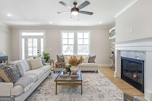 164 Palm St, Holly Springs, GA 30188 - living area with crown molding, a fireplace, plenty of natural light, light wood finished floors, and a ceiling fan