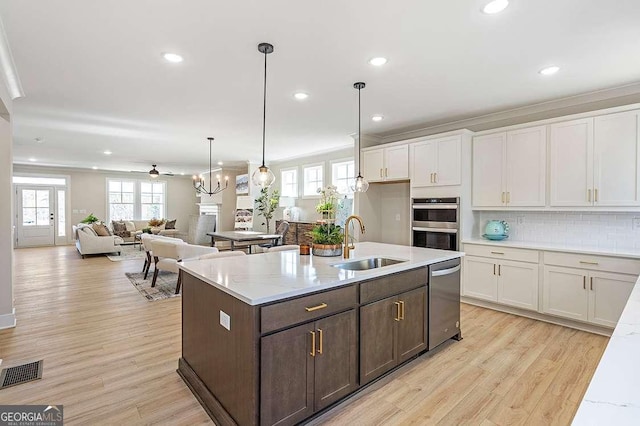 164 Palm St, Holly Springs, GA 30188 - kitchen with appliances with stainless steel finishes, white cabinetry, light wood-style flooring, dark brown cabinets, and recessed lighting