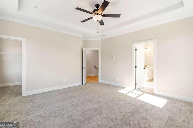 164 Palm St, Holly Springs, GA 30188 - unfurnished bedroom featuring a raised ceiling, light colored carpet, a walk in closet, ornamental molding, and a closet