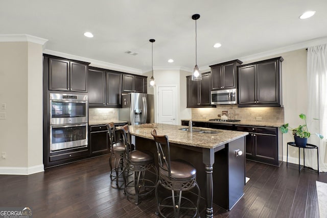 5640 Hammock Way, Cumming, GA 30028 - kitchen with appliances with stainless steel finishes, light stone countertops, dark wood-style floors, tasteful backsplash, and a breakfast bar