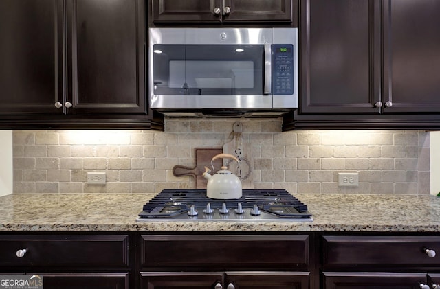 5640 Hammock Way, Cumming, GA 30028 - kitchen featuring stainless steel appliances, dark brown cabinetry, light stone countertops, and tasteful backsplash