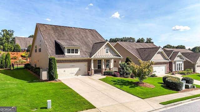 5640 Hammock Way, Cumming, GA 30028 - craftsman-style house with driveway, a front yard, brick siding, an attached garage, and board and batten siding