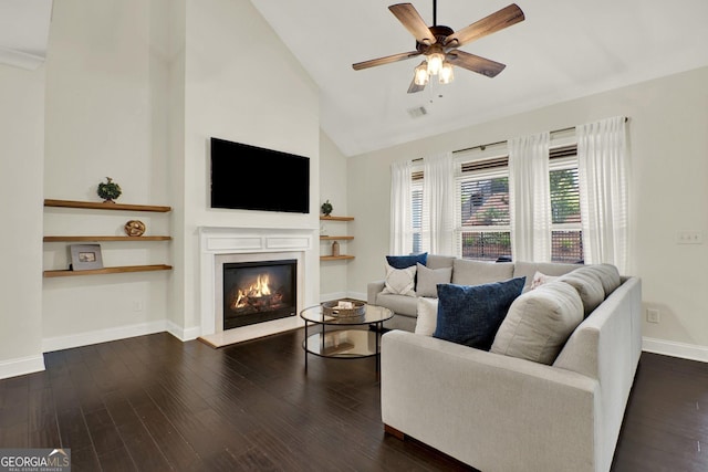 5640 Hammock Way, Cumming, GA 30028 - living area featuring a warm lit fireplace, high vaulted ceiling, a ceiling fan, and dark wood-type flooring
