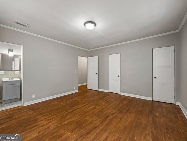 805 First Ave, Brunswick, GA 31520 - unfurnished bedroom with wood finished floors, crown molding, and ensuite bathroom